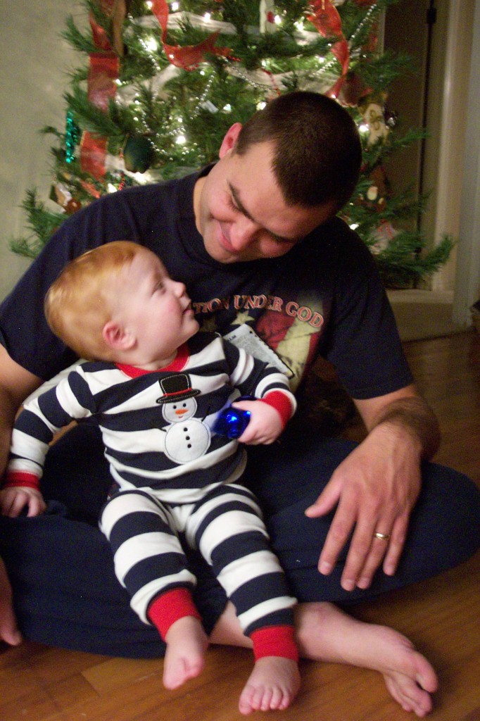 A father and his son beneath a Christmas tree.